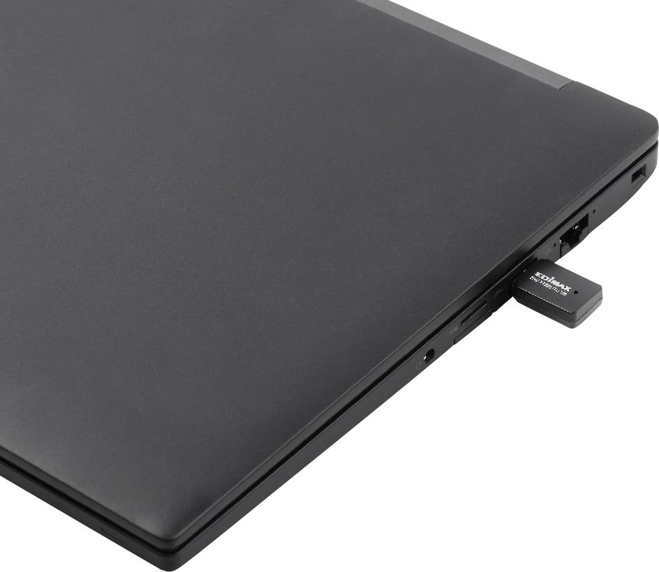 Laptop s USB flashdiskem zapojeným do bočního portu. Laptop je zavřený, černý povrch.