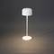 Moderní bílá stojací lampa s kulatým stínidlem a štíhlou základnou osvětluje světlým světlem šedou podlahu.