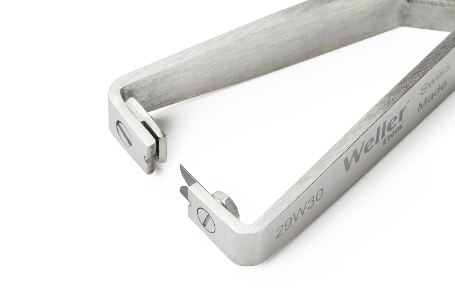 Stříbrný nástroj se dvěma hroty, který je používán pro přesné zásahy, má nápis 'Weller Tools' a 'Swiss Made'.