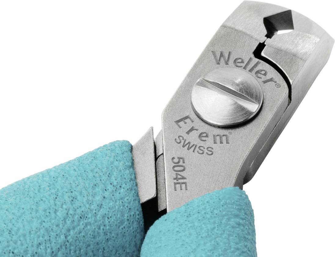 Detailní záběr stříbrných kleští s nápisem 'Weller Erem SWISS 504E', které drží osoba v tyrkysových rukavicích.