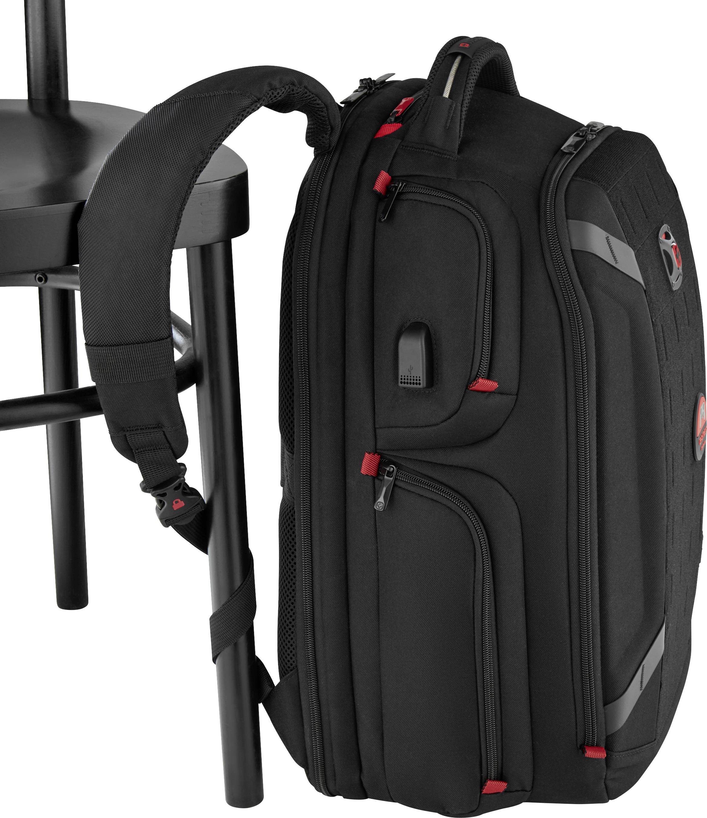 Černý batoh s červenými akcenty, připevněný na černé židli. Ergonomický design s několika zipovými kapsami.