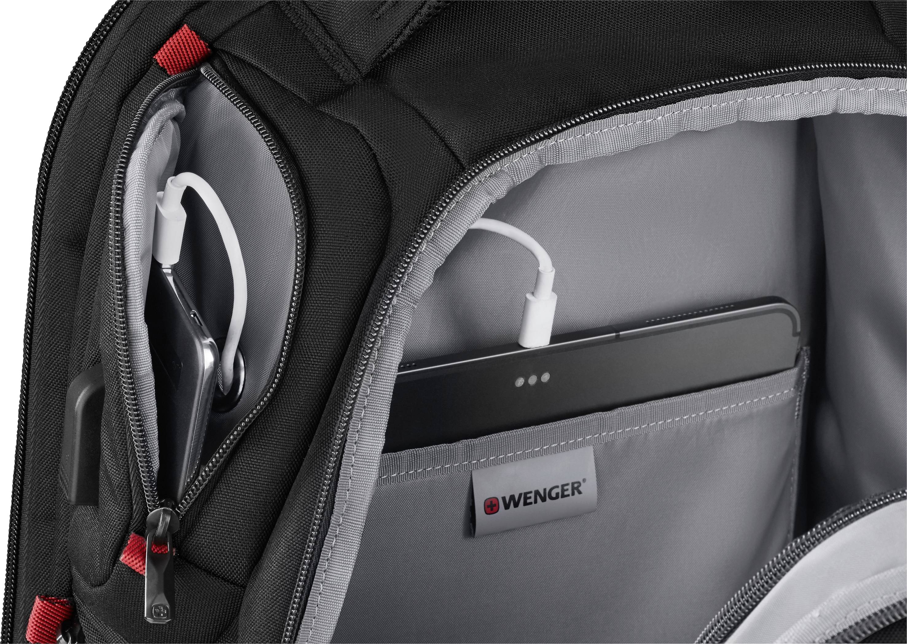 Otevřený batoh ukazuje několik kapes, včetně jedné určené pro tablet s USB portem. Uvnitř je štítek s názvem značky 'Wenger'.