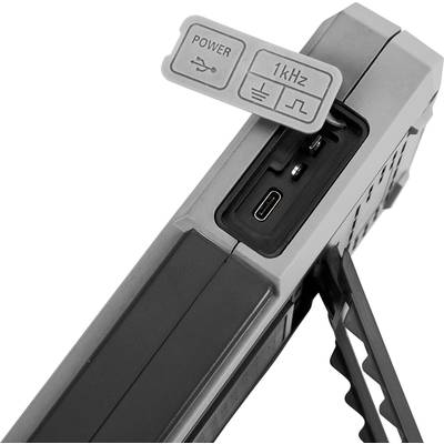 Elektronické zařízení s USB porty, napájecím konektorem a přepínačem 1 kHz. Boční podpora pro stabilitu.
