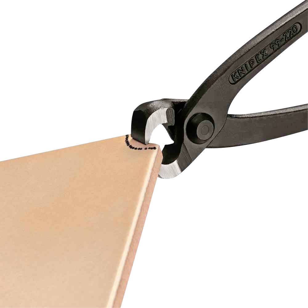 Černé kleště Knipex řežou těsně podél přímé linie na kousku materiálu.