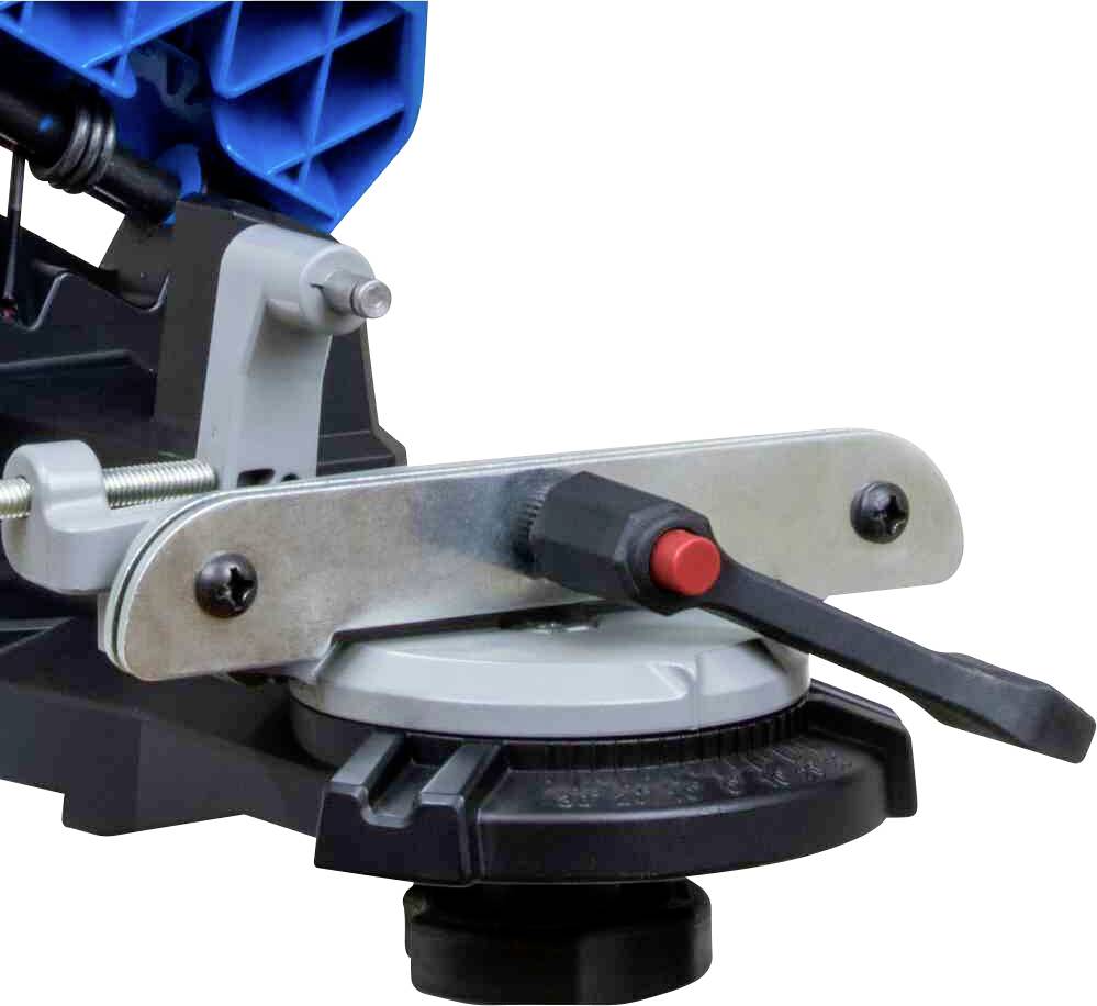 Detailní záběr mechanické páky přístroje s modrým krytem v pozadí, zobrazující technické detaily a šrouby.