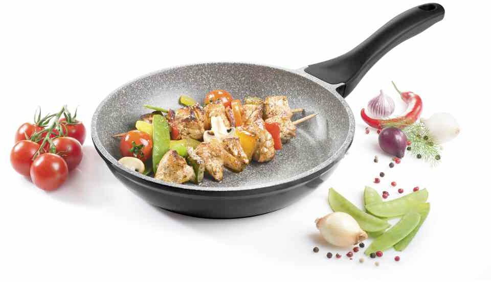 Pánev s grilovanými zeleninových špízy, obklopená čerstvou zeleninou jako jsou rajčata, papriky a cibule; prezentace kuchyňského náčiní a ingrediencí.