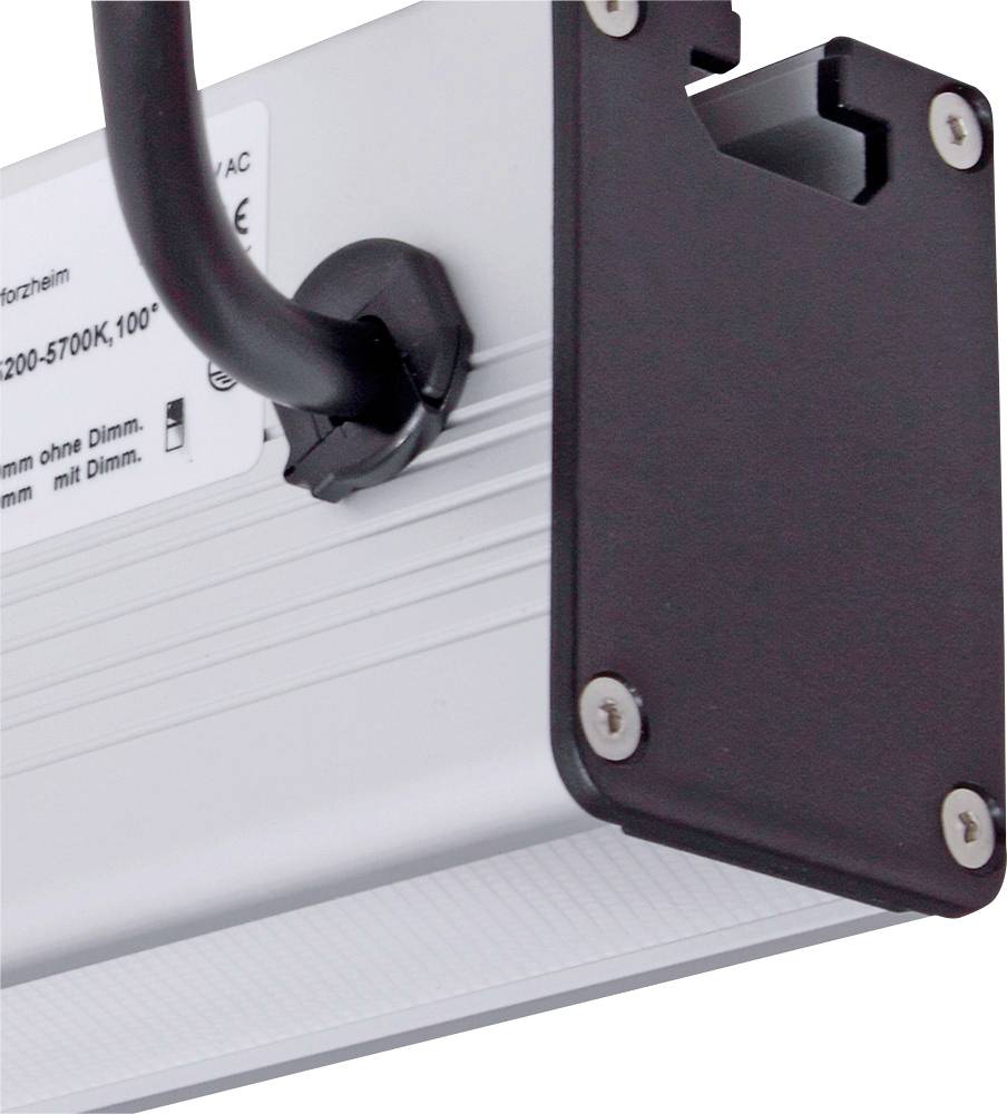 Detailní záběr elektrického zařízení se stříbrným tělem a černým upevňovacím prvkem, pravděpodobně lampy nebo osvětlovacího komponentu.