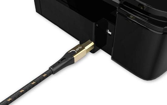 USB kabel je zasunuté do černé tiskárny. Hlavní fokus je kladen na propojení kabelu a tiskárny.