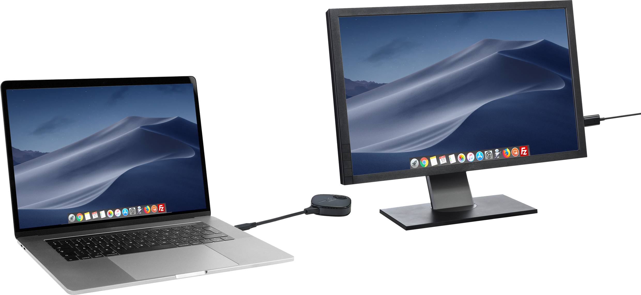 Notebook je připojen k externímu monitoru pomocí kabelu a adaptéru. Oba displeje zobrazují stejné pozadí s písečnými dunami.