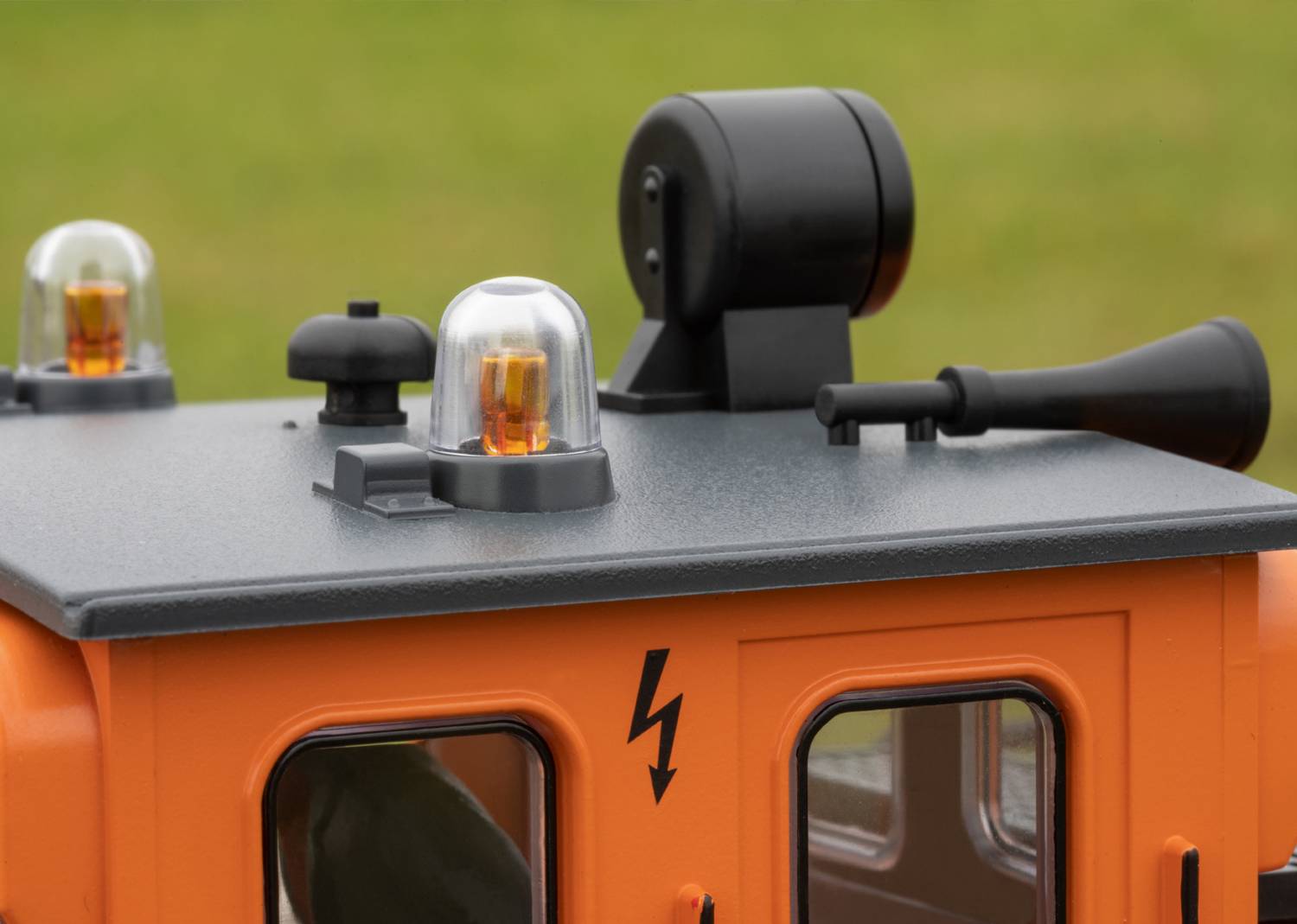 Oranžová modelová střecha vozidla s majákem a světlem, označená bleskem. Určeno pro venkovní použití.