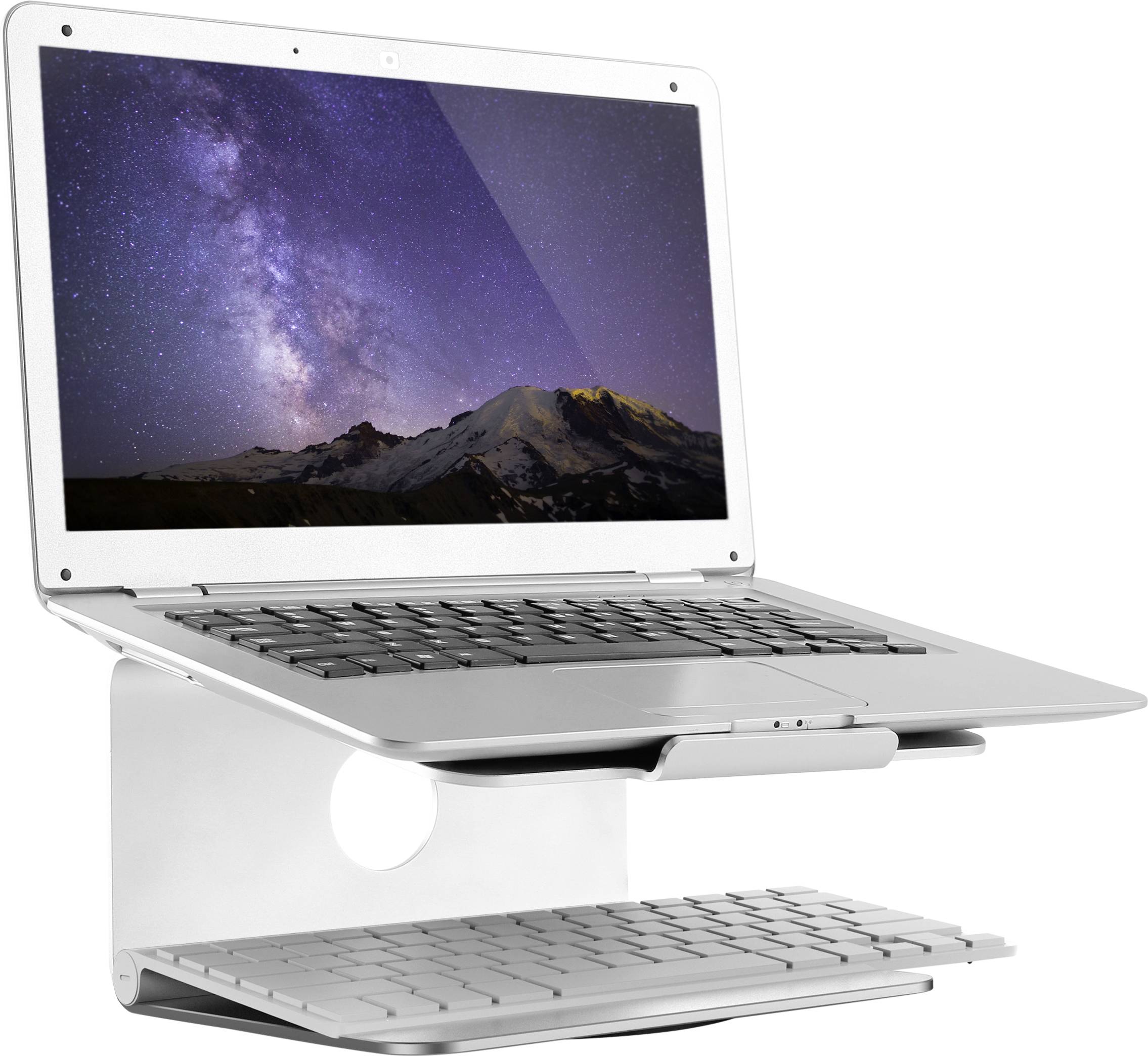 Laptop s obrázkem Mléčné dráhy na obrazovce stojí na stříbrném stojánku. Bezdrátová klávesnice leží pod ním.