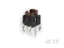 Elektronický spínač s několika kovovými kolíky pro montáž na desku plošných spojů, černý s hnědou spínací částí.