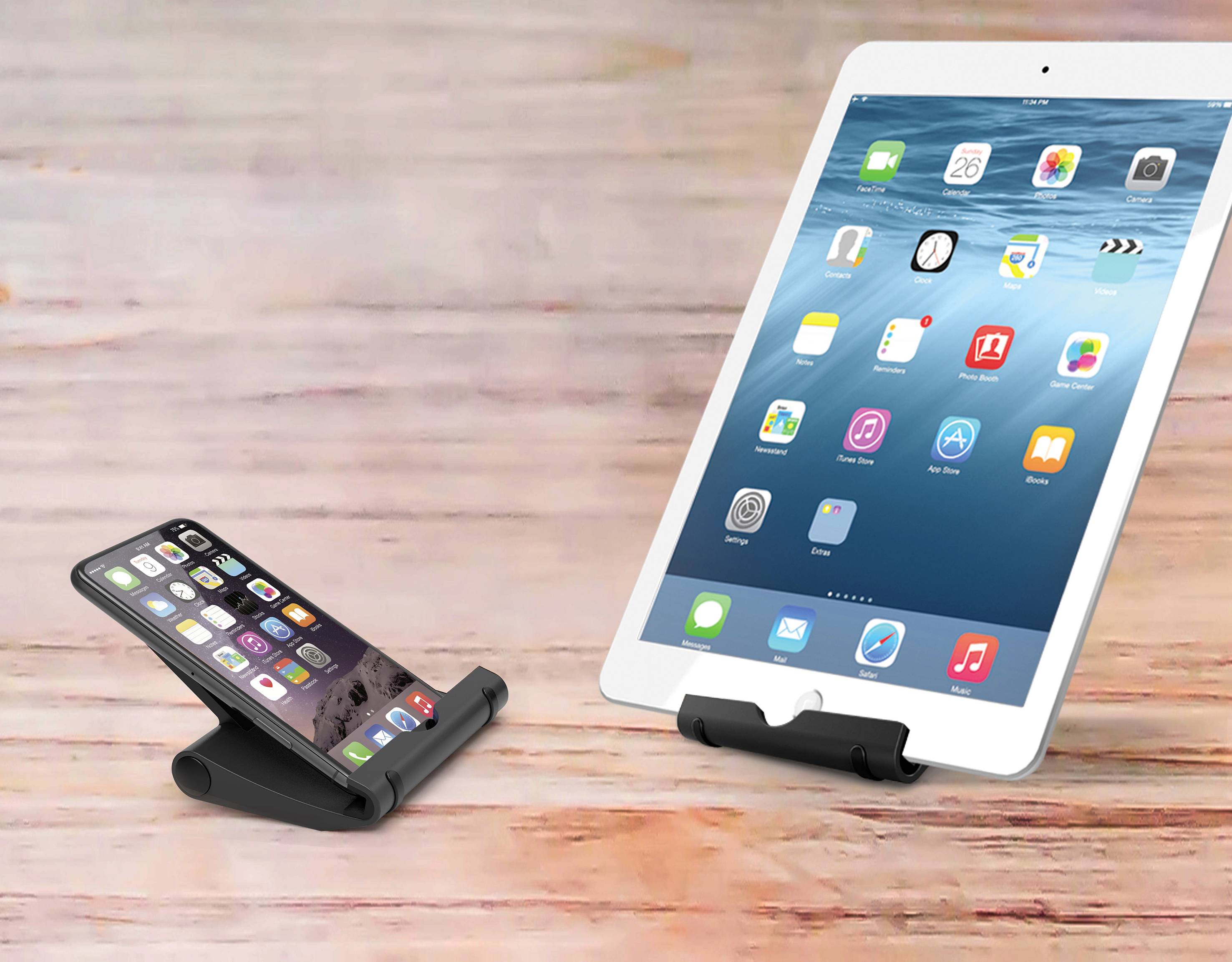 Smartphone a tablet leží na dřevěném povrchu, každé v černém stojánku. Oba přístroje zobrazují své úvodní obrazovky.