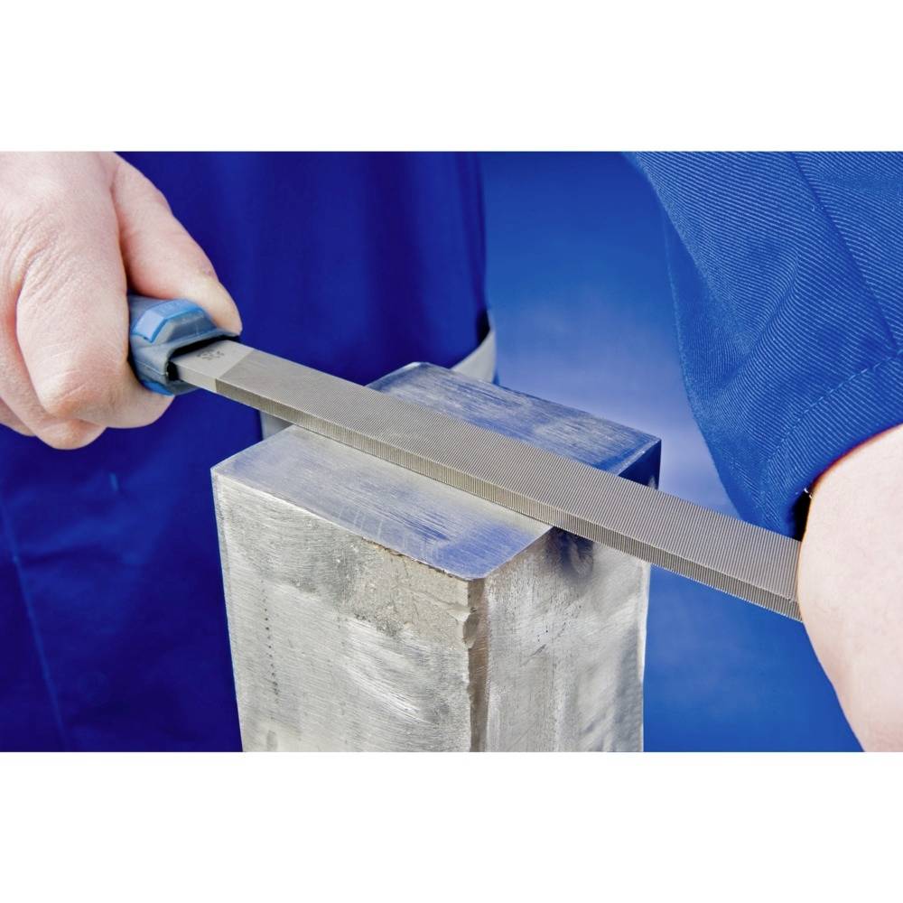 Osoba piluje kovový kus plochým pilníkem a má na sobě modré ochranné oblečení.