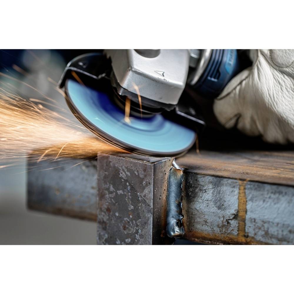 Úhlová bruska řeže modrou kotoučem skrz kovový díl, od místa kontaktu odlétávají jiskry. Rukavice drží nástroj.