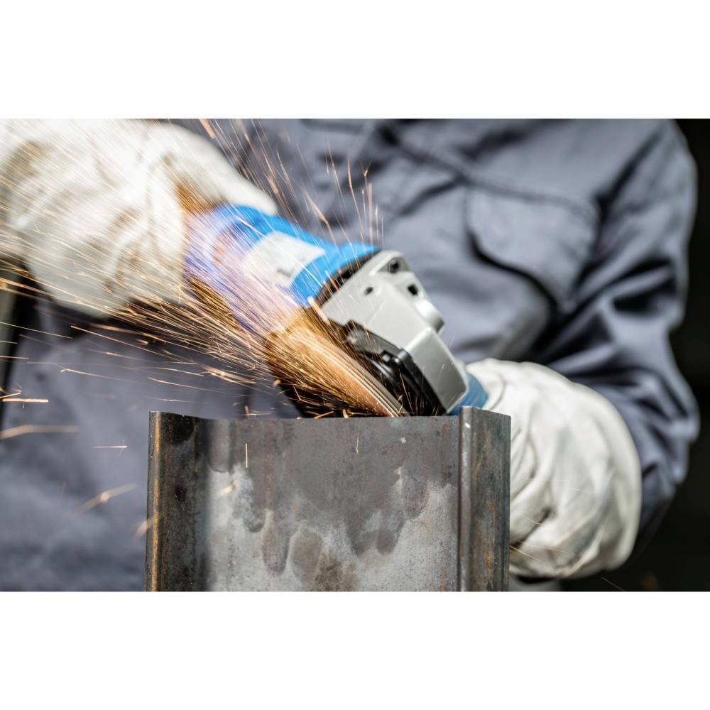 Osoba v ochranných prostředcích brousí kovový kus úhlovou bruskou. Od kovu odlétávají jiskry.