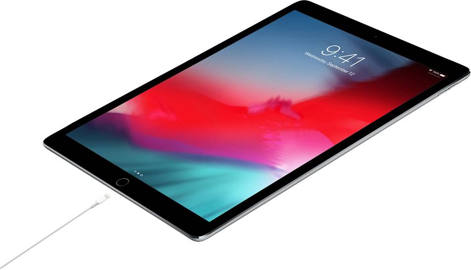 Tablet s aktivním displejem zobrazuje čas 9:41. Je nabíjen pomocí nabíjecího kabelu.