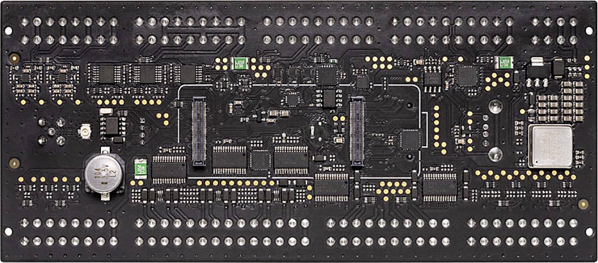 Černá deska plošných spojů s četnými elektronickými komponenty, čipy a sloty, pravděpodobně určená pro počítačem řízené aplikace.