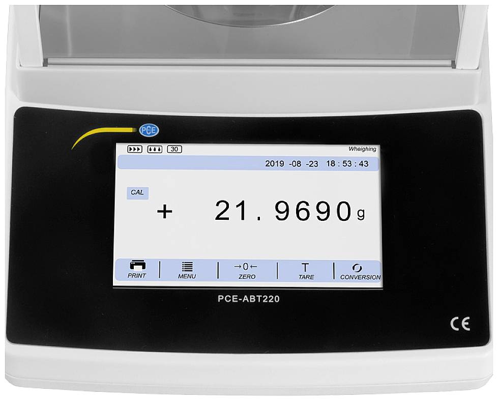 Elektronická váha s digitálním displejem. Zobrazuje hmotnost: 21,9690 g. Tlačítka pro tisk, menu, nulu, tárování a převod jednotek.