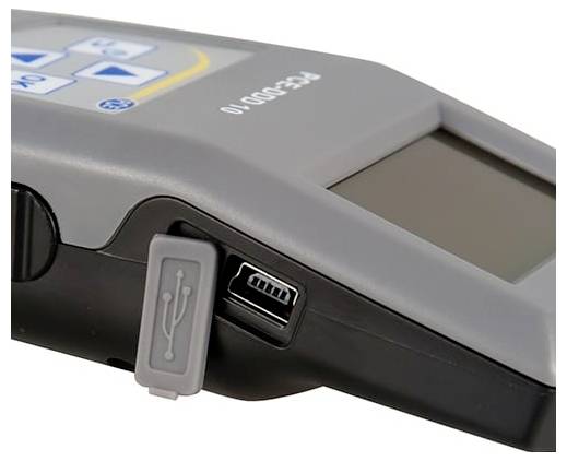 Detailní záběr přenosného zařízení s portem USB a ochranným krytem, zobrazující malý ovládací panel a displej.