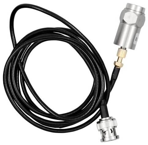 Černý stočený kabel s kovovými konektory a stříbrným válcovým senzorem nebo adaptérem na bílém pozadí.
