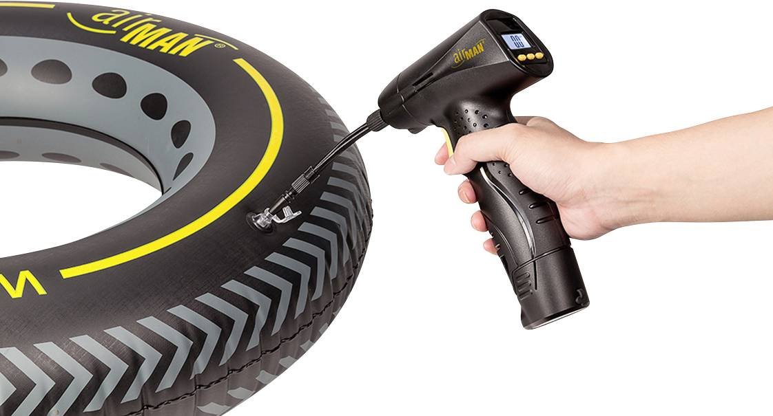 Jedna ruka drží elektrickou vzduchovou pumpu, která právě nafukuje pneumatiku. Pneumatika má černý a žlutý design.