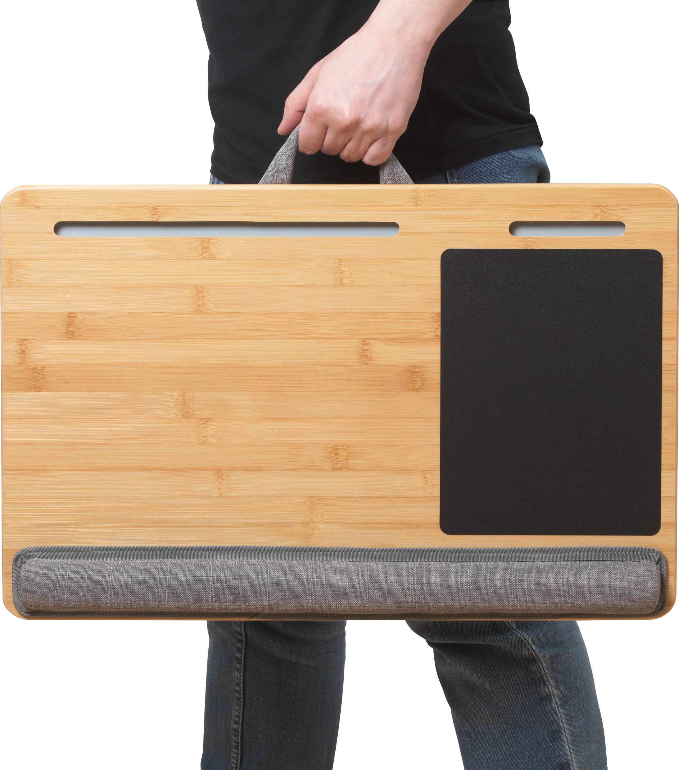 Osoba nese přenosný bambusový lapdesk s podložkou pod myš, rukojetí a polstrovanou základnou. Ideální pro pohodlné používání notebooků na cestách.