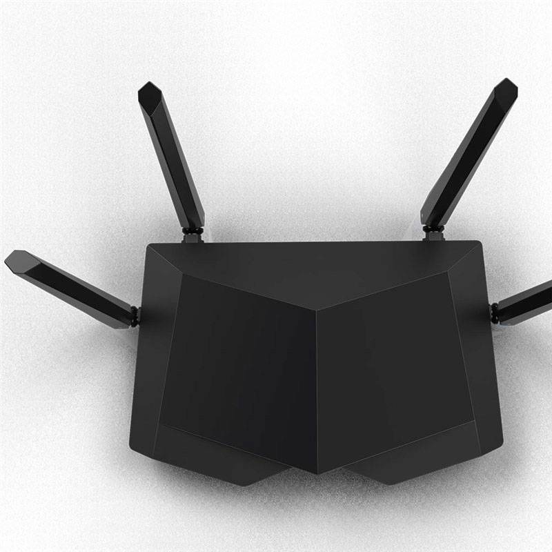 Černý WLAN router se čtyřmi šikmo nahoru směřujícími anténami, umístěný na šedém povrchu.