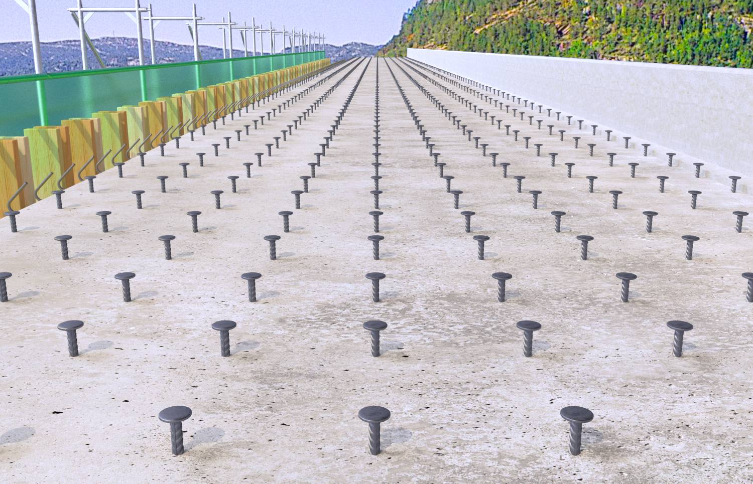 Řada šroubových pilot na betonu, lemovaná zábranami a hromadami zeminy, symbolizuje připravené staveniště nebo základy.