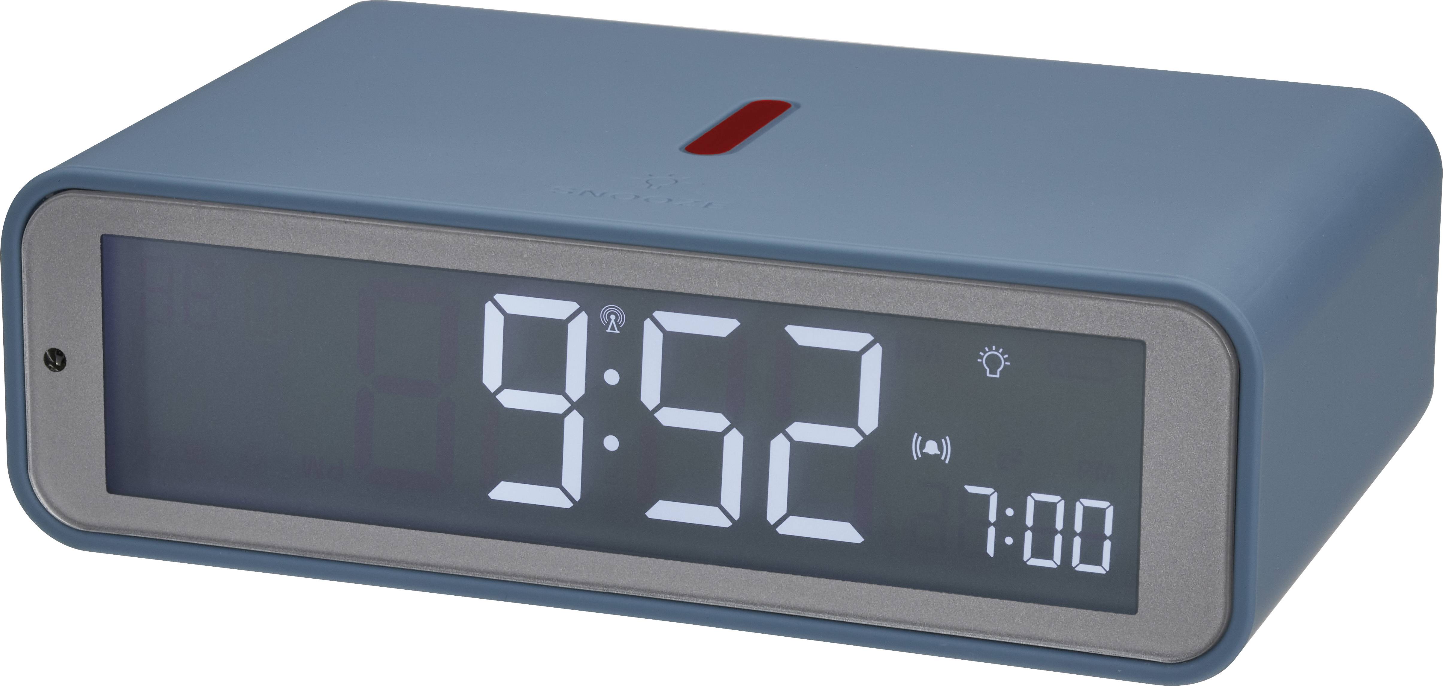 Modrý digitální budík ukazuje 9:52. Alarm je nastaven na 7:00. Nahoře se nachází červené tlačítko.