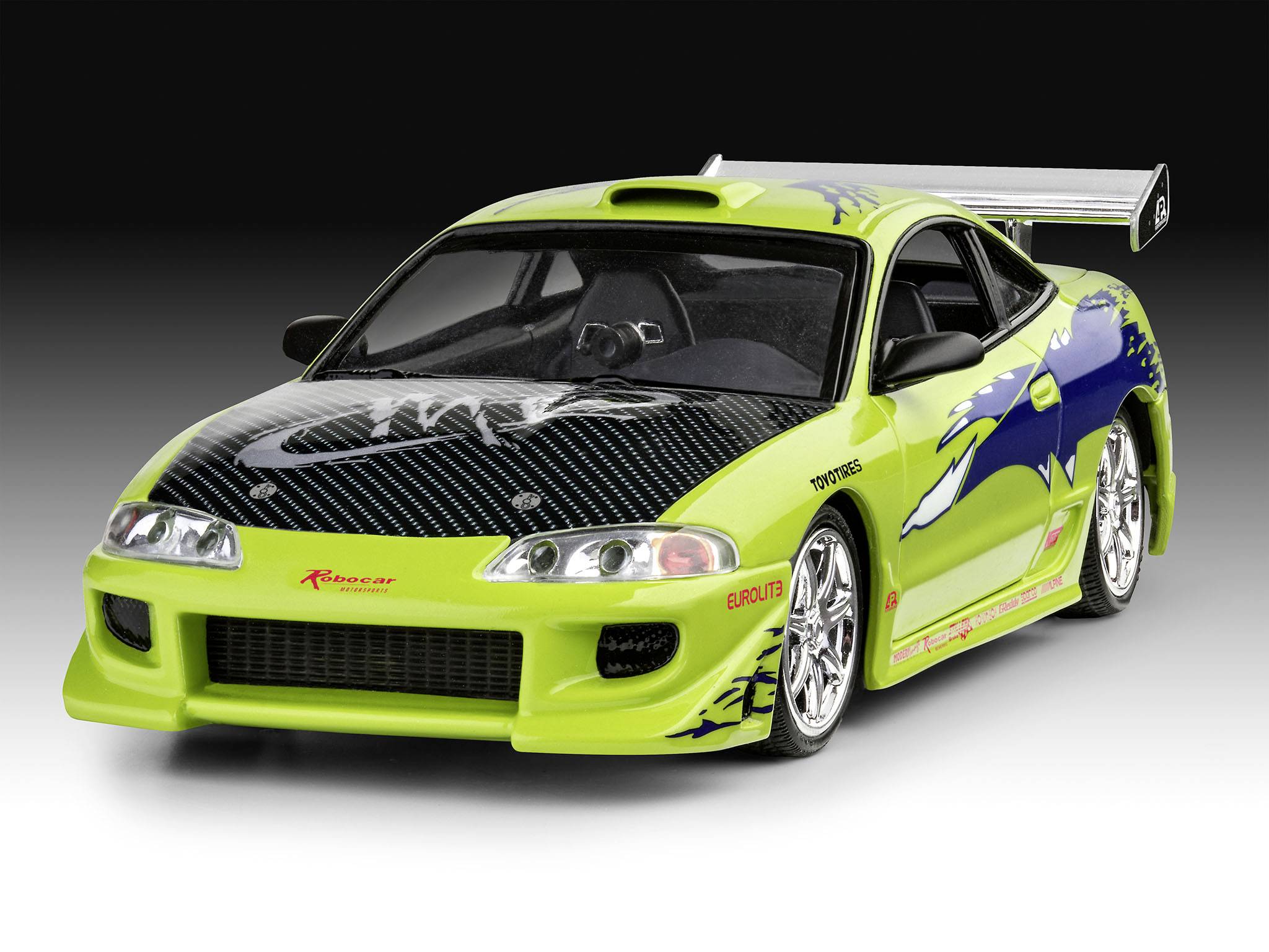 Jasně zelené sportovní auto s černou kapotou a velkým zadním křídlem, zaparkované na šedém pozadí. Model vozu: Toyota Supra.