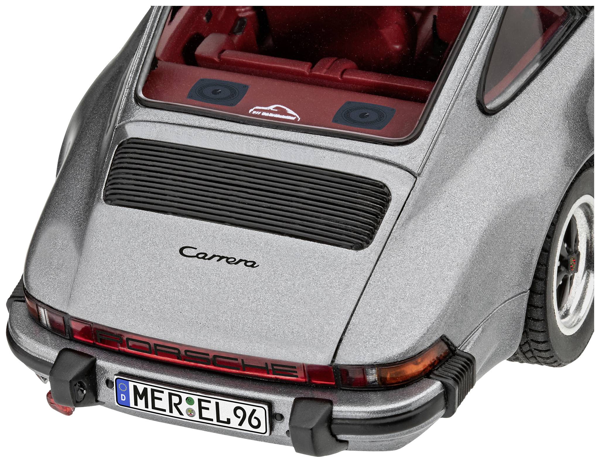 Šedé auto zezadu s otevřeným víkem kufru, klasický design. Text na kufru: 'Carrera' a poznávací značka 'MER-EL 96'.