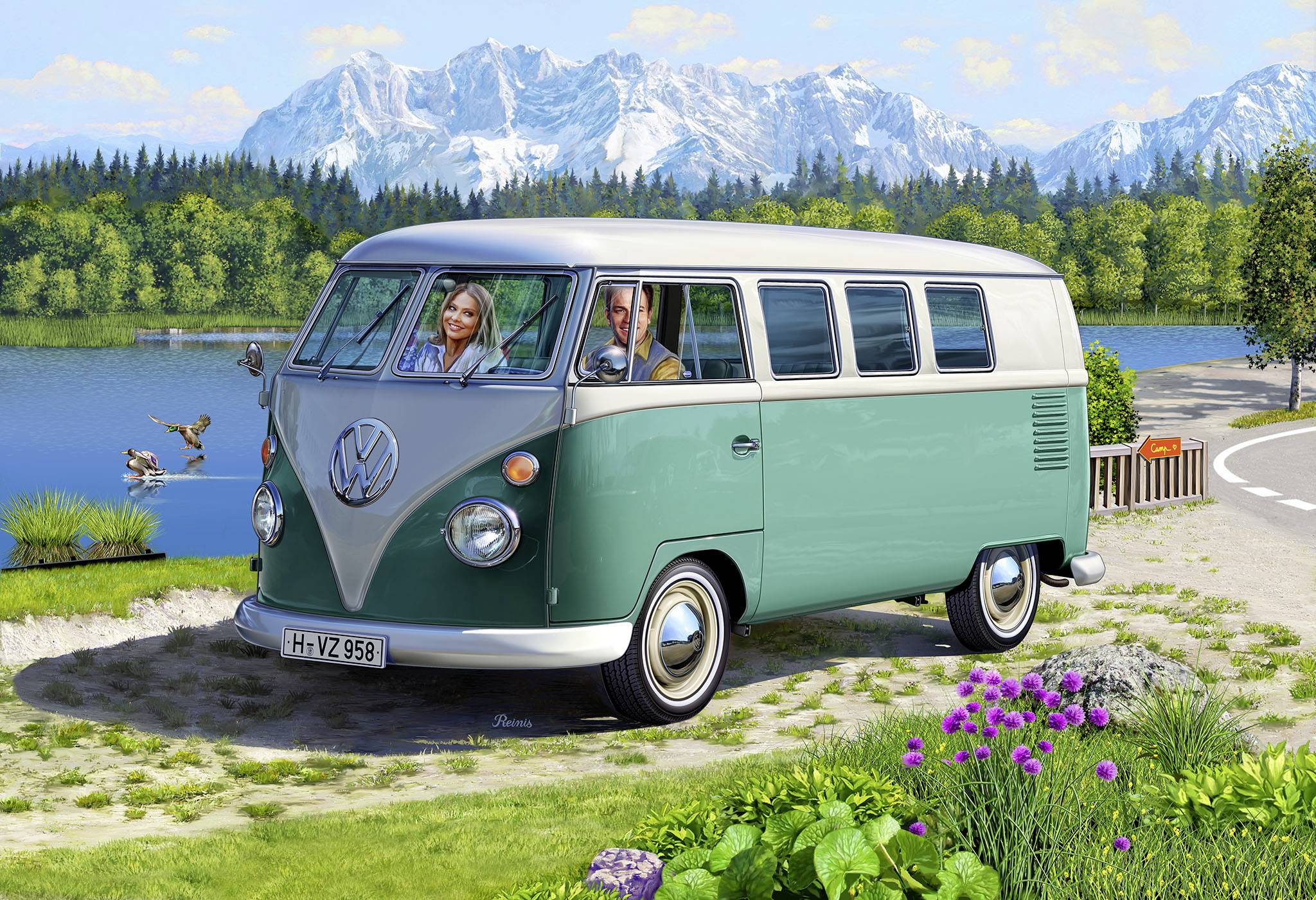 Staré zelené obytné auto stojí na břehu jezera. Dvě osoby sedí vpředu, v pozadí jsou vidět hory.