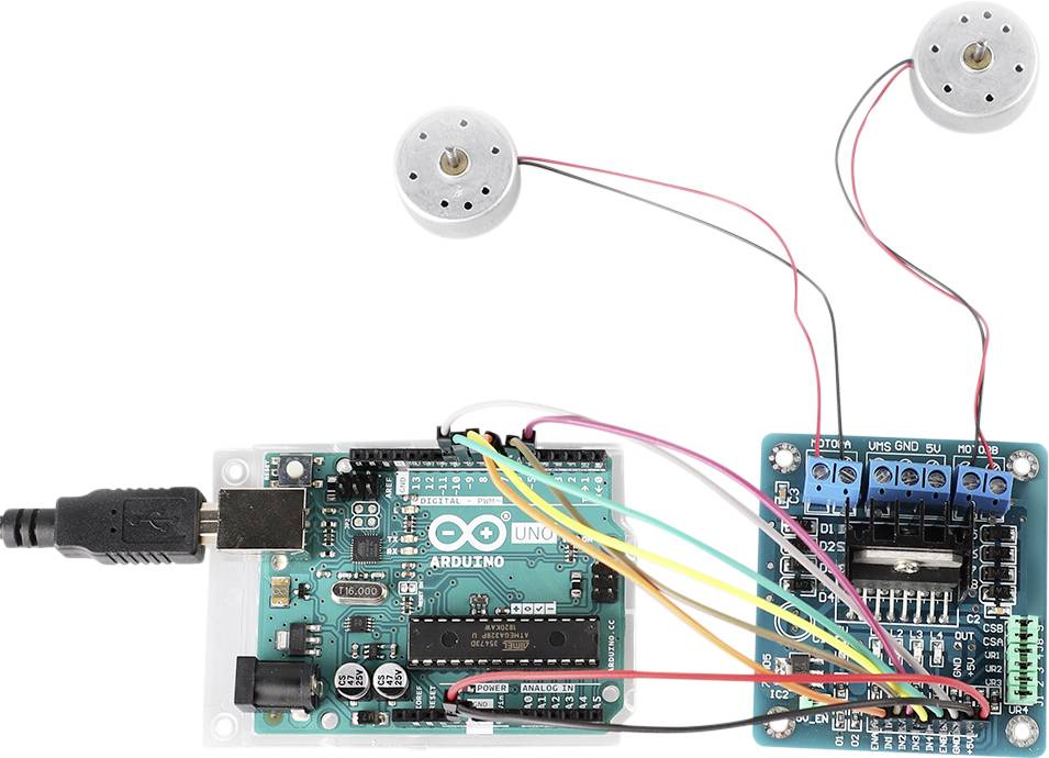 Arduino deska s připojeným modulem pro řízení motorů a dvěma malými motory. Barevné kabely propojují jednotlivé komponenty.
