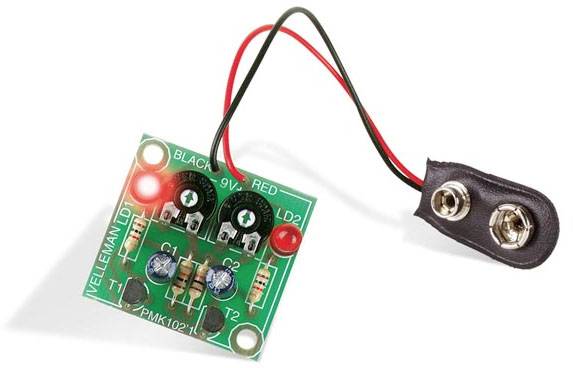 Elektronický stavebnicový set s deskou plošných spojů, LED diodami, rezistory a vodiči pro připojení 9V baterie, určený k demonstraci jednoduchých elektrických obvodů.