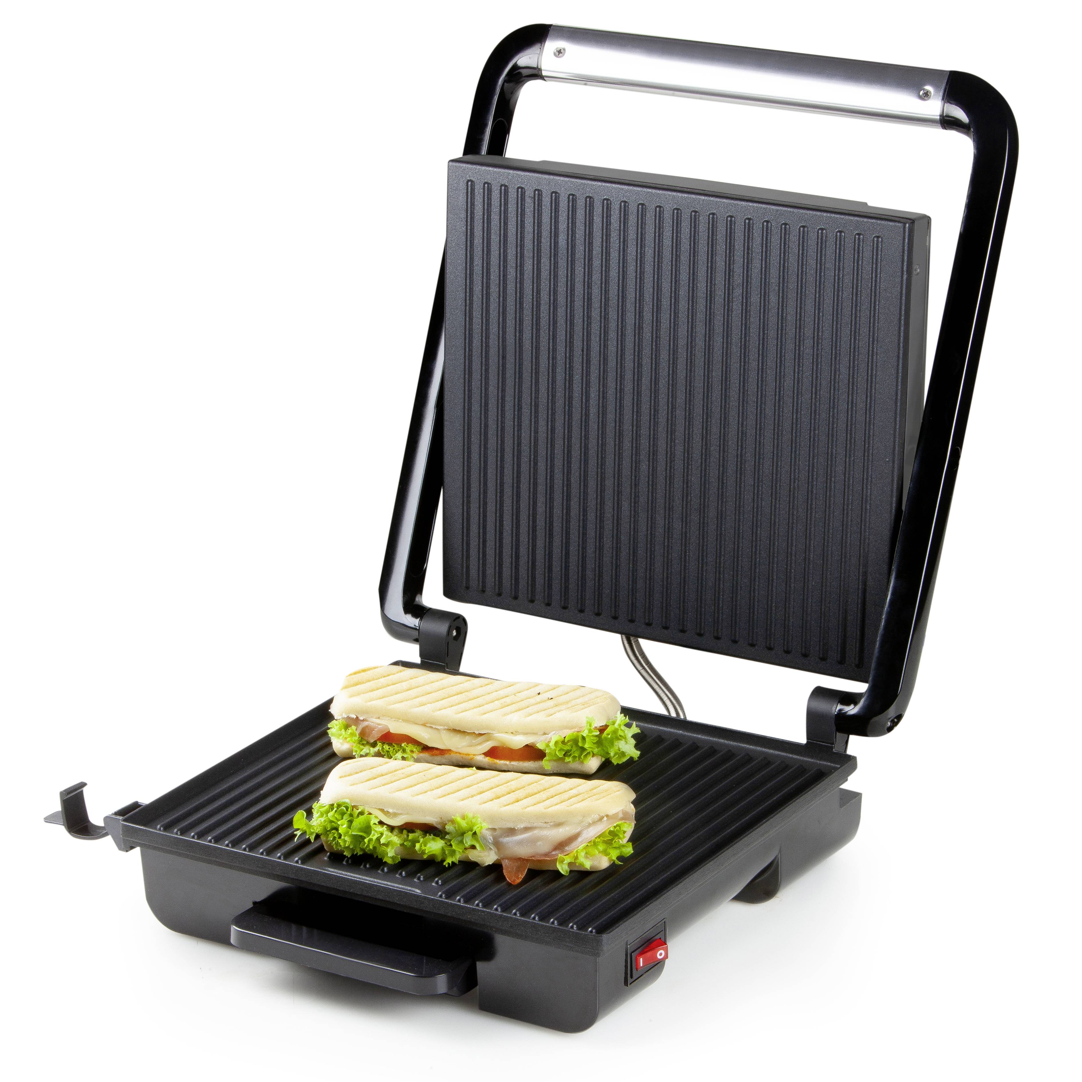 Dva panini sendviče s listem a kuřecím masem se opékají na elektrickém grilu.