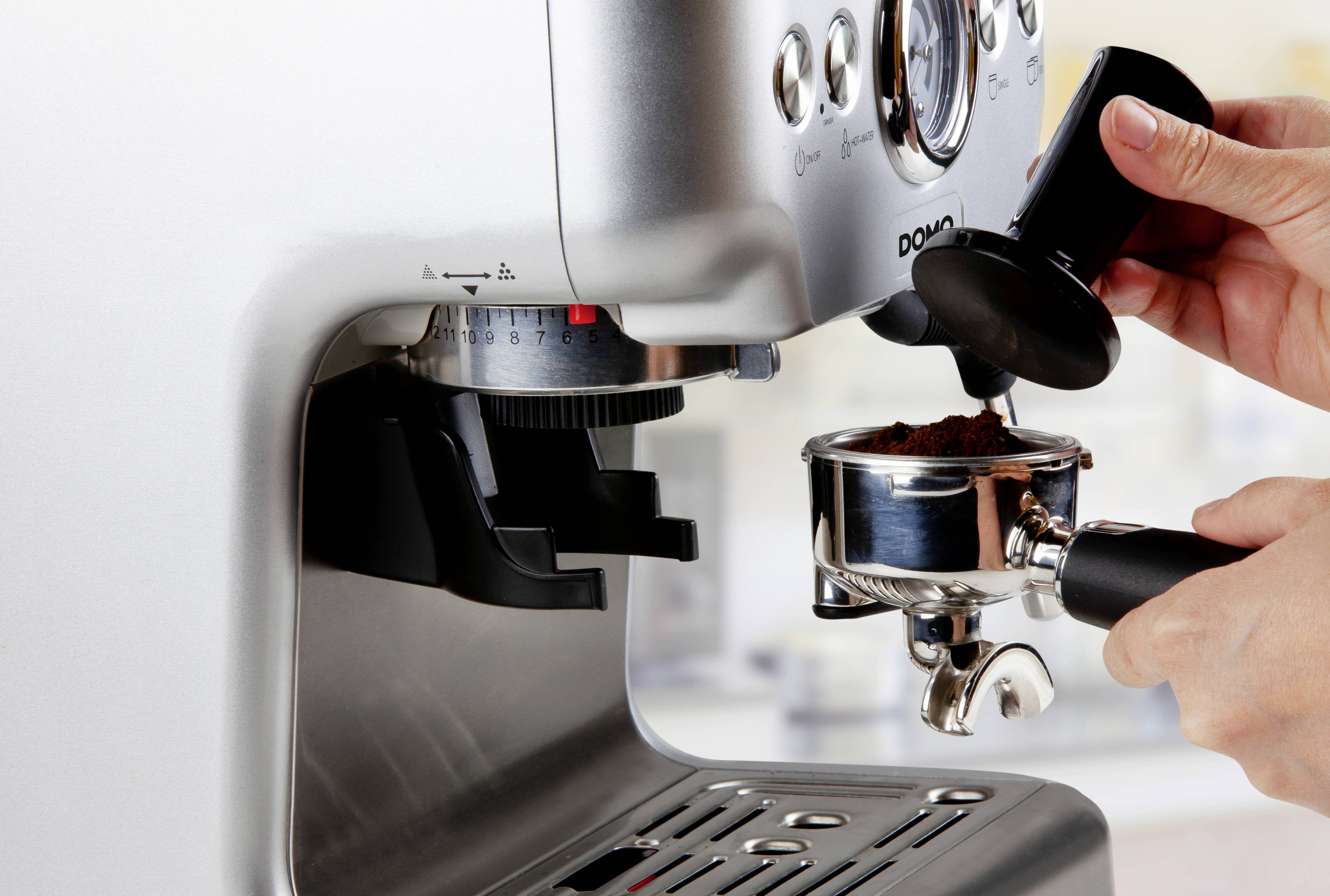 Osoba mele kávu do pákovače pro espresso.