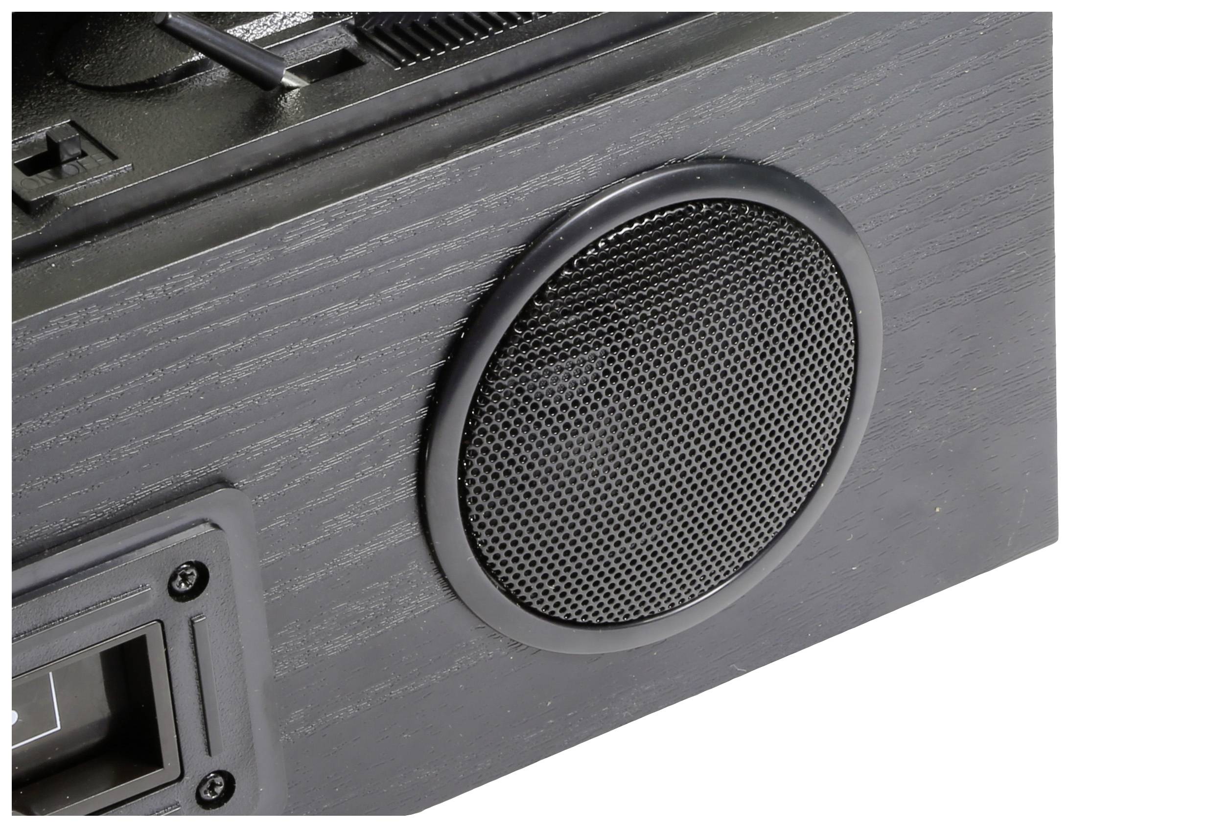 Detailní záběr černého reproduktoru v dřevěné skříni, který je součástí většího audiosystému.