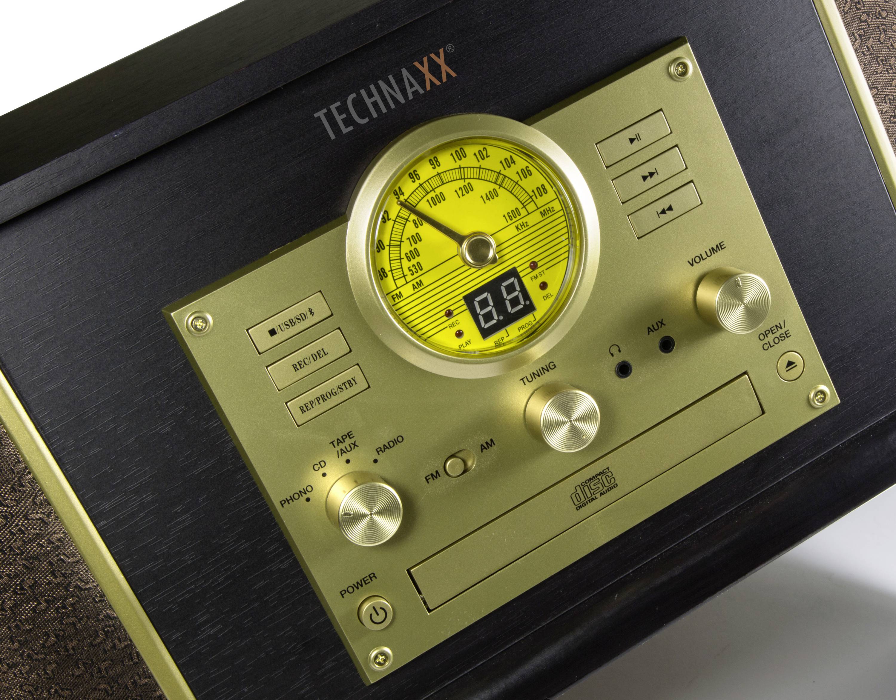 Starý rádiomagnetofon se zlatým předním panelem, osvětleným frekvenčním displejem a několika ovládacími prvky pro rádio a CD.