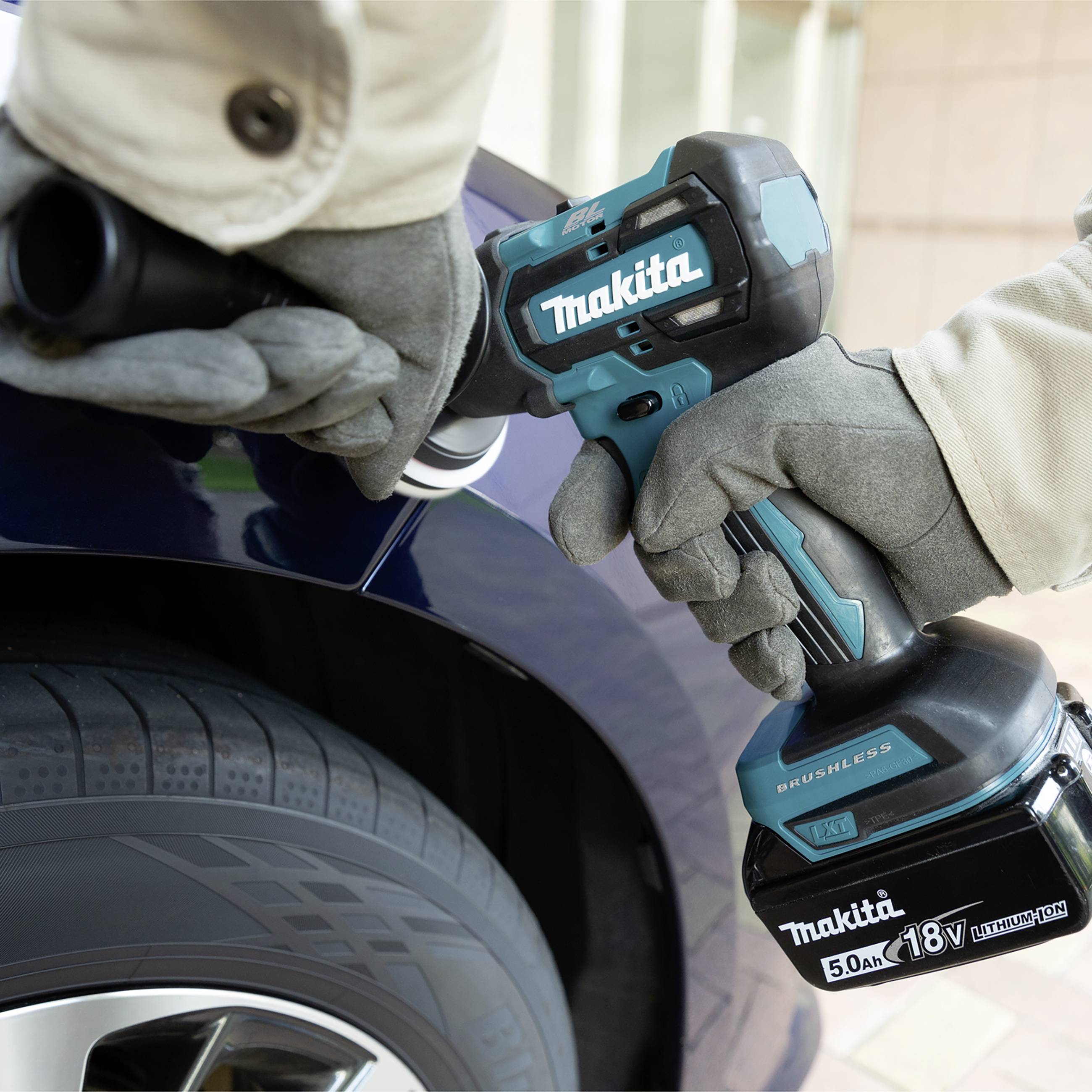Osoba používá bezdrátový rázový utahovák k uvolnění matice kola na pneumatice automobilu.