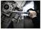 Osoba používající momentový klíč k utažení šroubu na mechanické součásti, což ukazuje přesnost v mechanické práci.