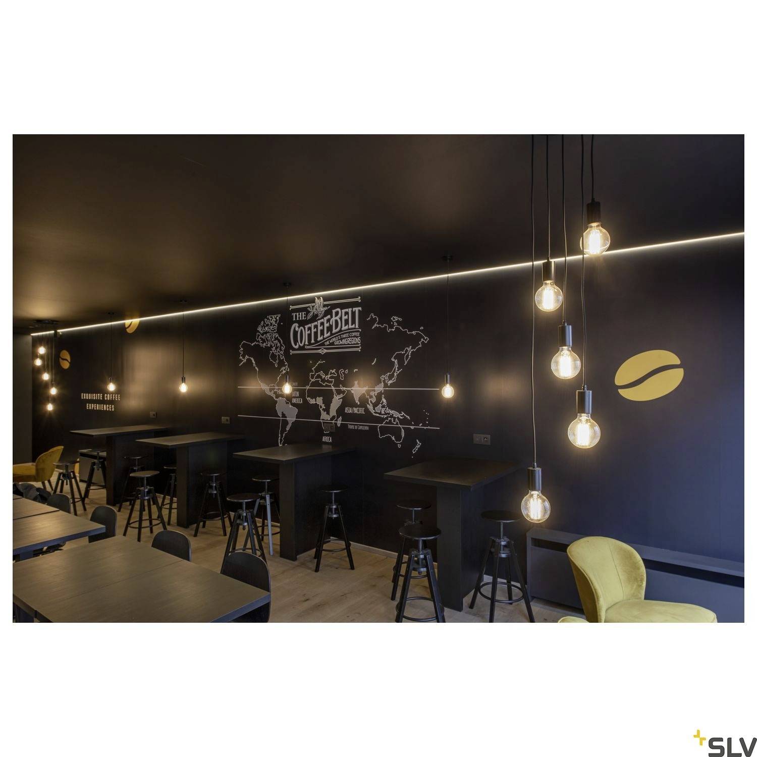 Útulná kavárna s elegantně zařízeným interiérem, na jehož stěně visí mapa s nápisem 'The Coffee Belt'. Závěsné lampy a dřevěný nábytek vytvářejí příjemnou atmosféru.