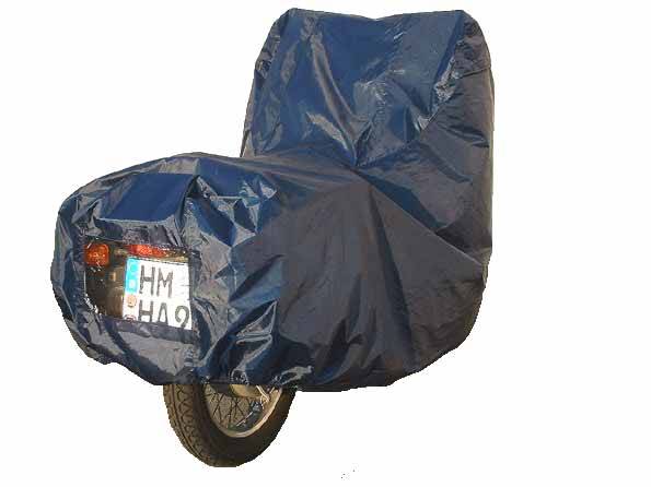 Motocykl s modrým krycím plachtou, poznávací značka viditelná.