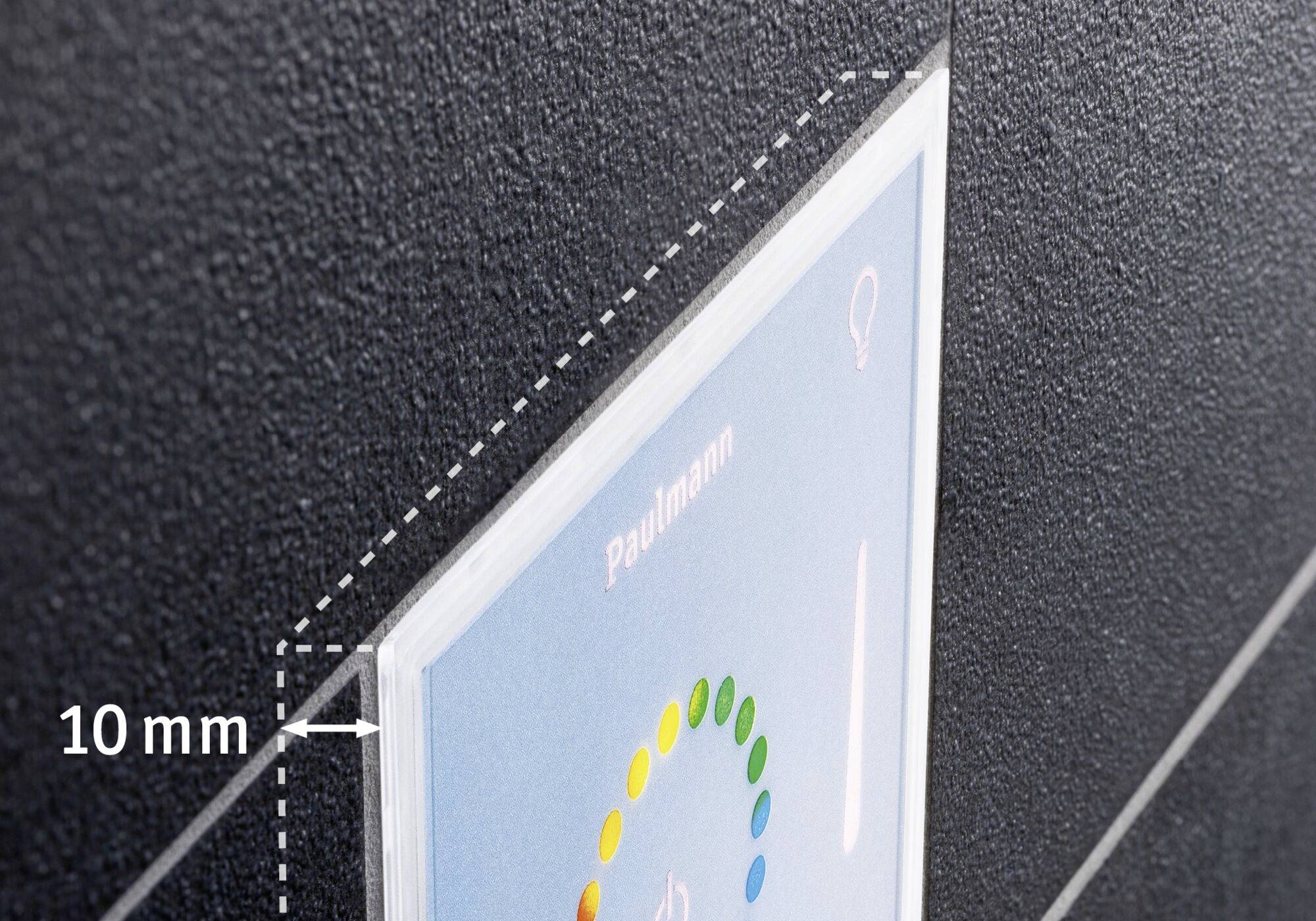 Spínač s LED světelným indikátorem, který zobrazuje nápis 'Paulmann'. Montáž ukazuje 10 mm odstup od povrchu stěny.