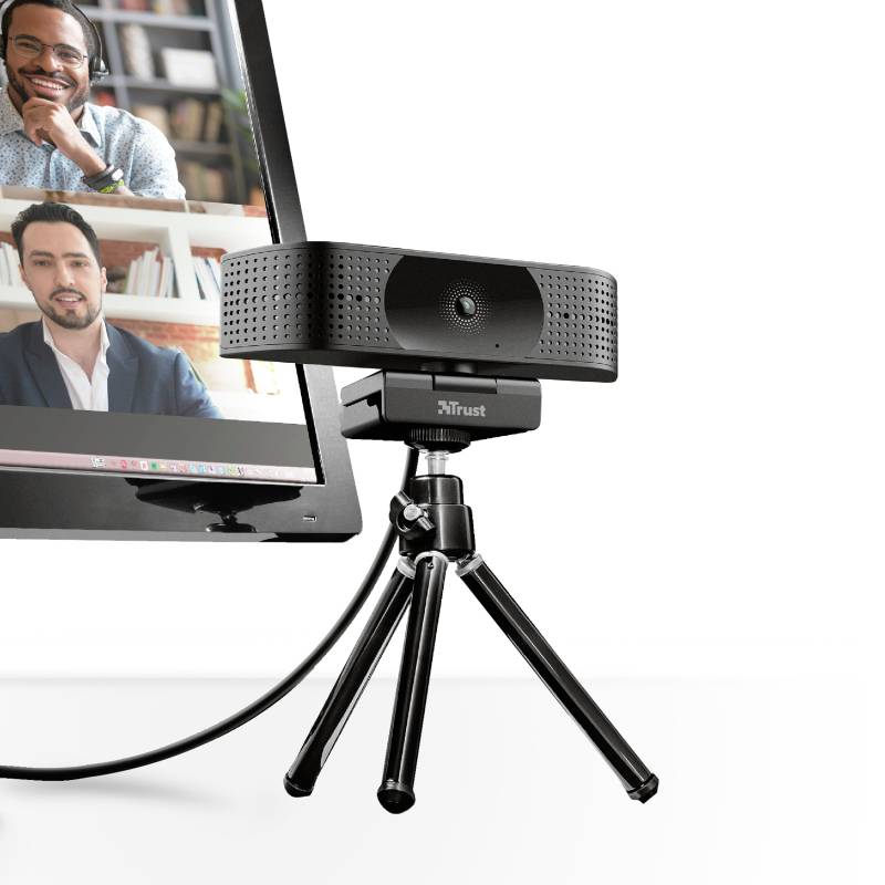 Webová kamera na stativu stojí před monitorem, na kterém je zobrazena videokonference se dvěma účastníky.