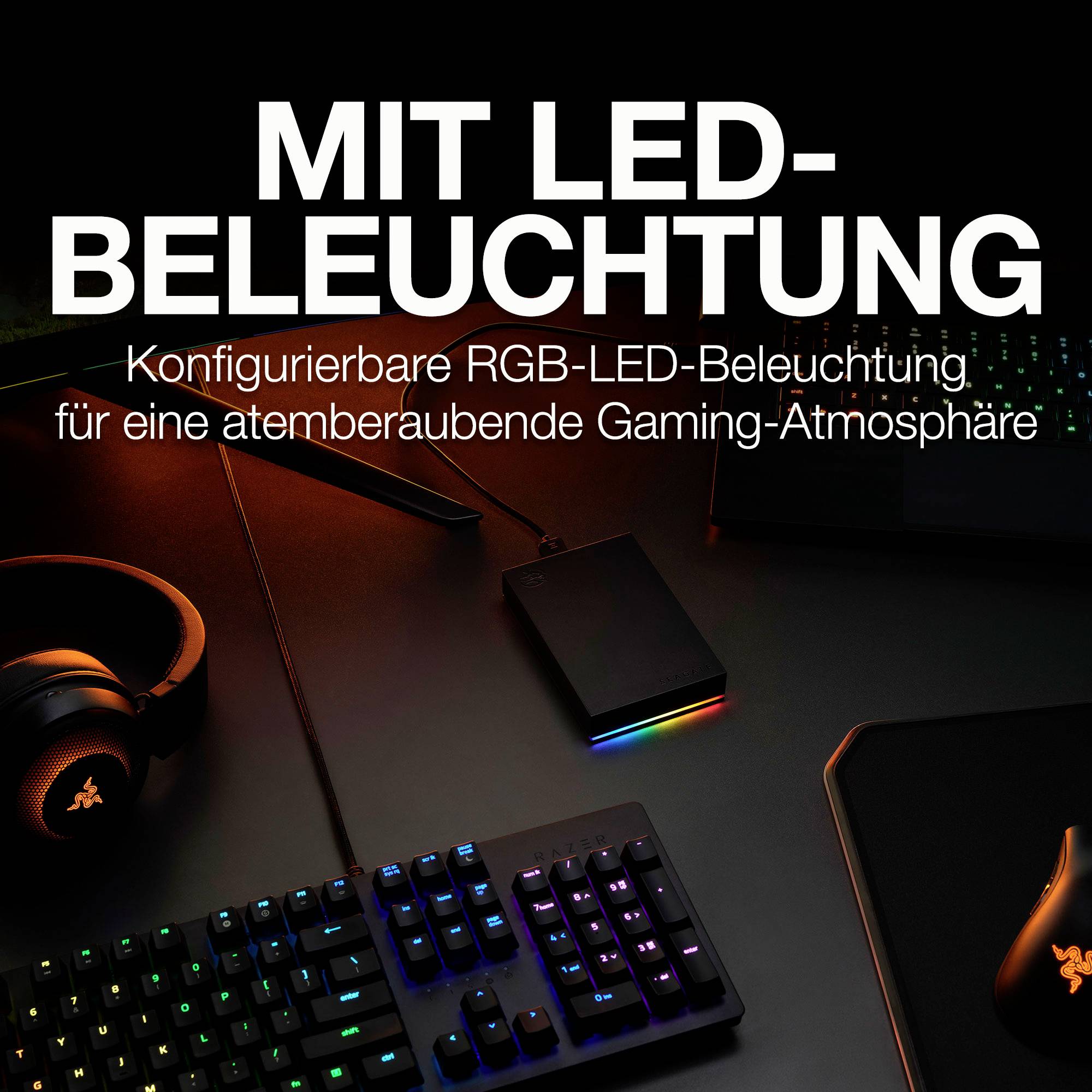 'S LED osvětlením: Konfigurovatelné RGB LED osvětlení pro úchvatnou herní atmosféru.' Herní sestava s podsvícenou klávesnicí, myší a headsetem.
