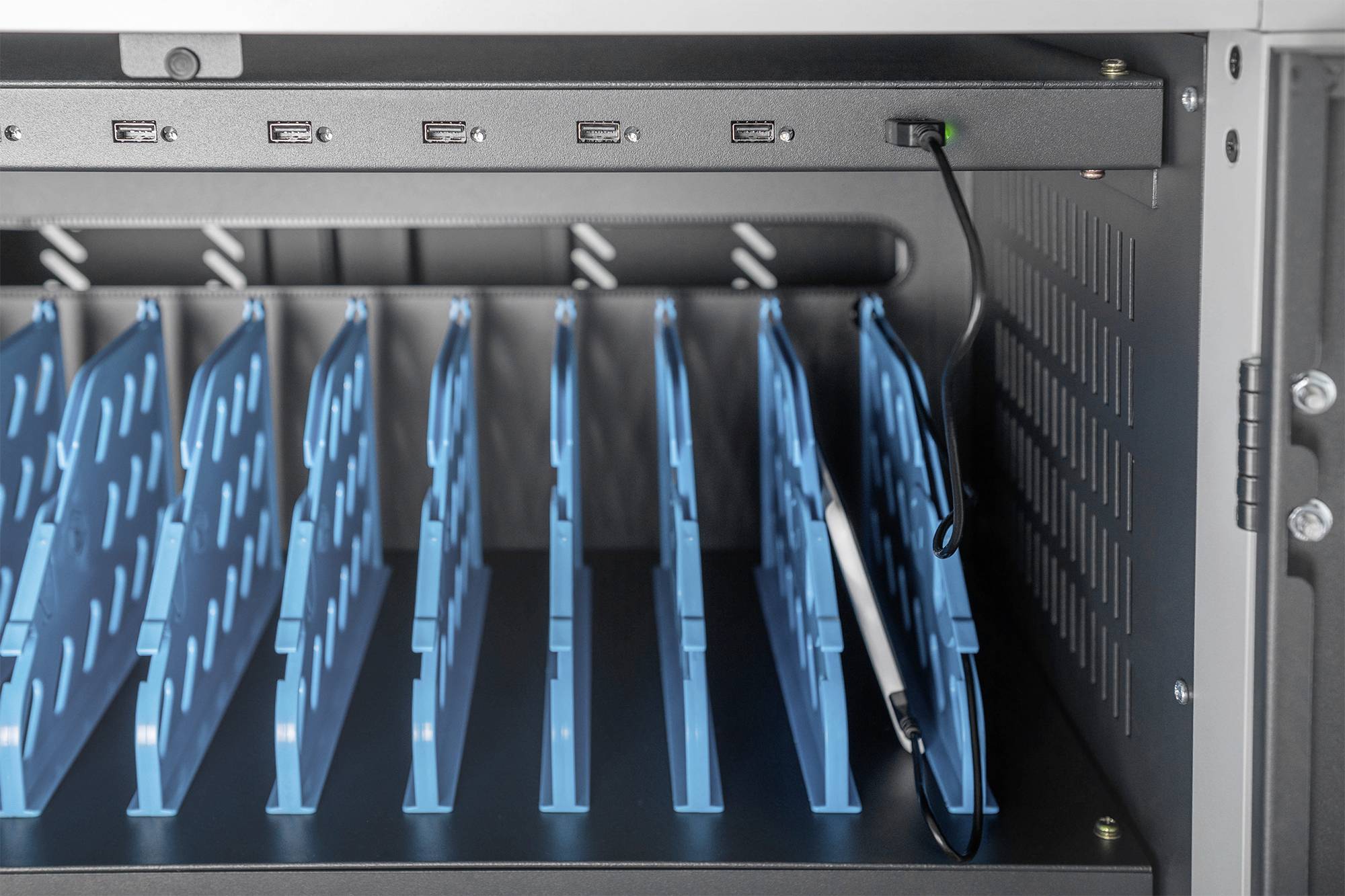 Úložná skříň na notebooky s několika modrými přihrádkami a USB porty pro organizaci a nabíjení elektronických zařízení.