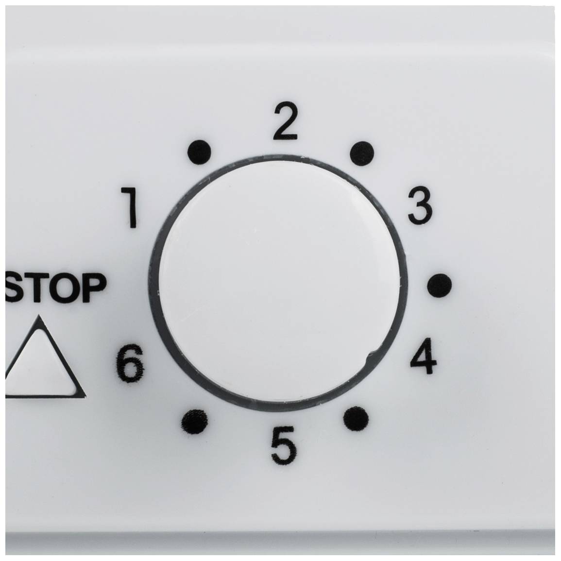 Otočný knoflík na zařízení ukazuje čísla 1 až 6, přičemž je knoflík nastaven na číslo '2'. Vlevo od něj je napsáno 'STOP'.