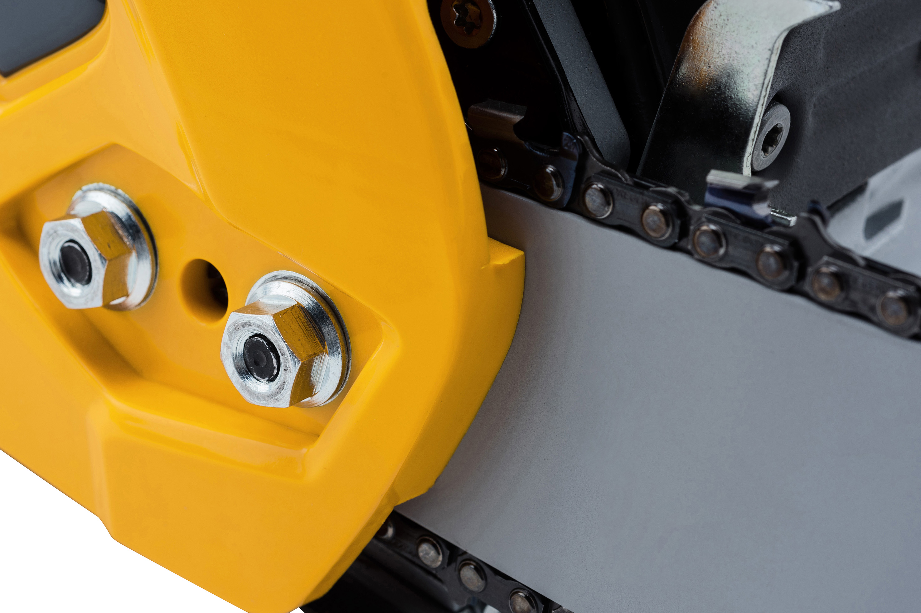 Detailní záběr motorové pily ukazuje lištu a řetěz. Žlutý kryt poskytuje ochranu, zatímco stříbrný řetěz je viditelný.
