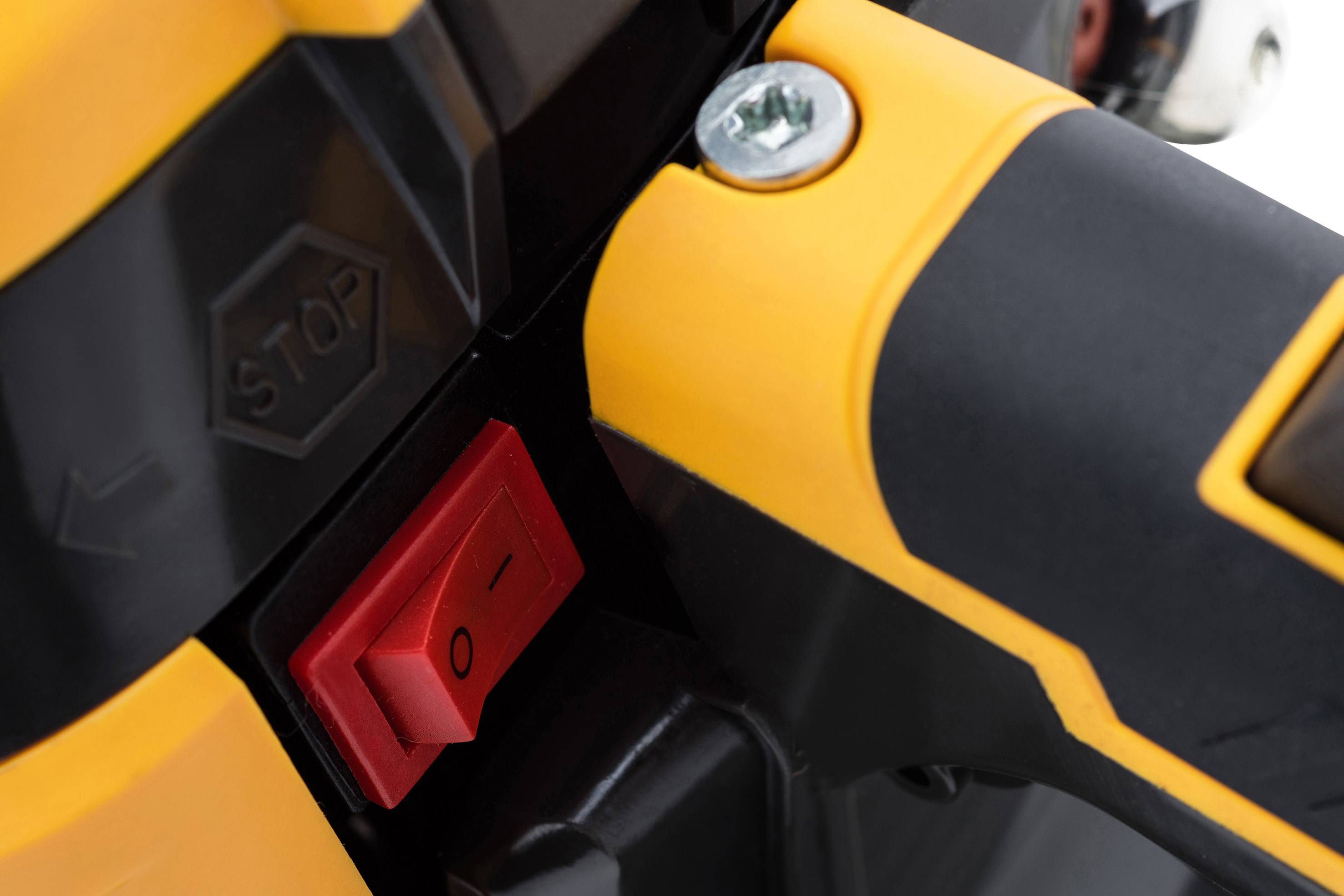 Detailní záběr oranžovo-černého elektrického zařízení s červeným tlačítkem zapnutí/vypnutí a tlačítkem "STOP".